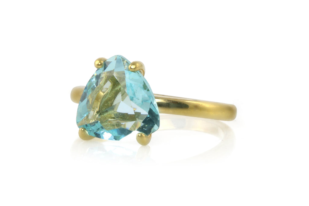 a gold ring with a blue topazte stone